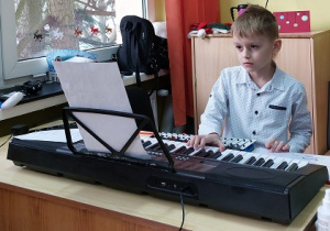 Patrtyk z klasy 1 a gra kolędę na keyboardzie.
